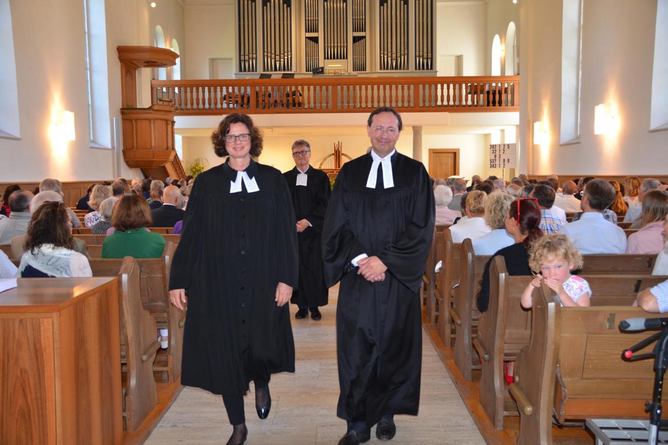 Schreiten nach dem festlichen Gottesdienst durch die Kirche: Pfarrerin Sabine Schüz und Pfarrer Kai Hinz, in der Mitte
Kirchenratspräsident Wilfried Bührer. (Bild: Margrith Pfister-Kübler)
