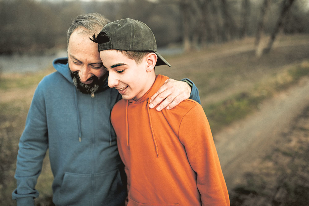 Vater und Sohn im vertrauten Gespräch auf einem Spaziergang.