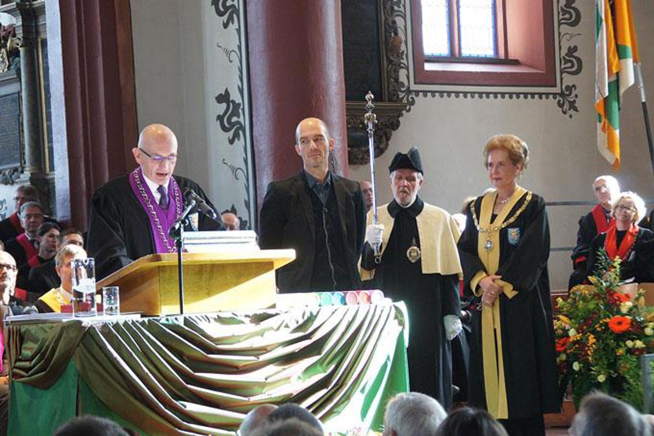 (v. l.) Georg Pfleiderer, Dekan der Theologischen Fakultät in Basel, verleiht am Dies academicus vom 24. November in Basel dem Kinderliedermacher Andrew Bond die Ehrendoktorwürde im Beisein von Andrea Schenker-Wicki, Rektorin der Universität Basel. | zVg