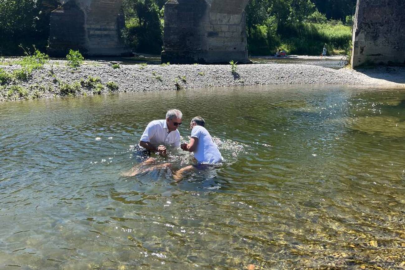 Pfarrer Paul Wellauer (links) taucht bei der Alten Thurbrücke in Bischofszell Täufling Matija Frauchiger ins Wasser. (Bild: Micha Frauchiger)