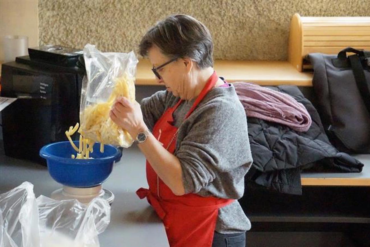 Kirchenrätin Annina Policante portioniert für «Tischlein deck dich» Pommes-frites, die von den Grossverteilern nicht mehr verkauft werden. Foto: Stefan Degen