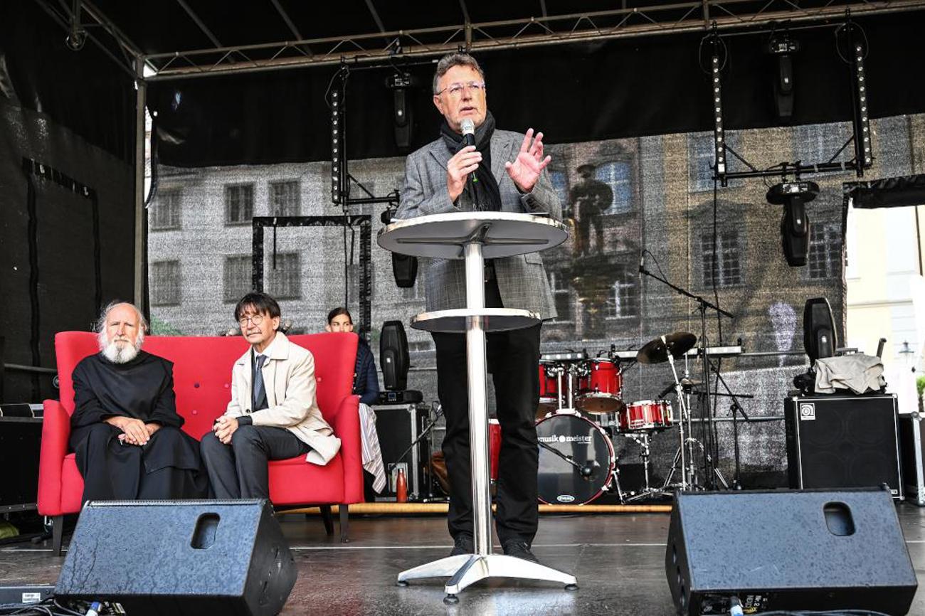 Eröffnung des Kirchentags mit Kirchenratspräsident Wolfram Kötter, im Hintergrund Pater Anselm Grün und Stadtrat Raphael Rohner auf dem roten Sofa.