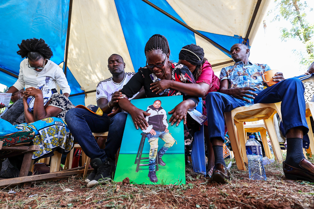 Bibiana Wangari (Mitte) hält während der symbolischen Beerdigung ein Bild ihres im Krieg in der Ukraine getöteten Sohnes Charles Waithaka Wangari. Ob sein Leichnam je zurück nach Kenia gebracht wird, ist unklar. | epd/Duncan Mwathi