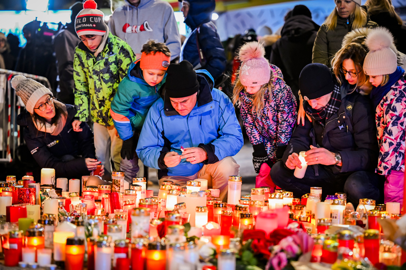 Ein Lichtermeer an Kerzen in Crans-Montana. Eltern zünden gemeinsam mit ihren Kindern Lichter zum Gedenken an die Opfer der Brandkatastrophe an. | Keystone
