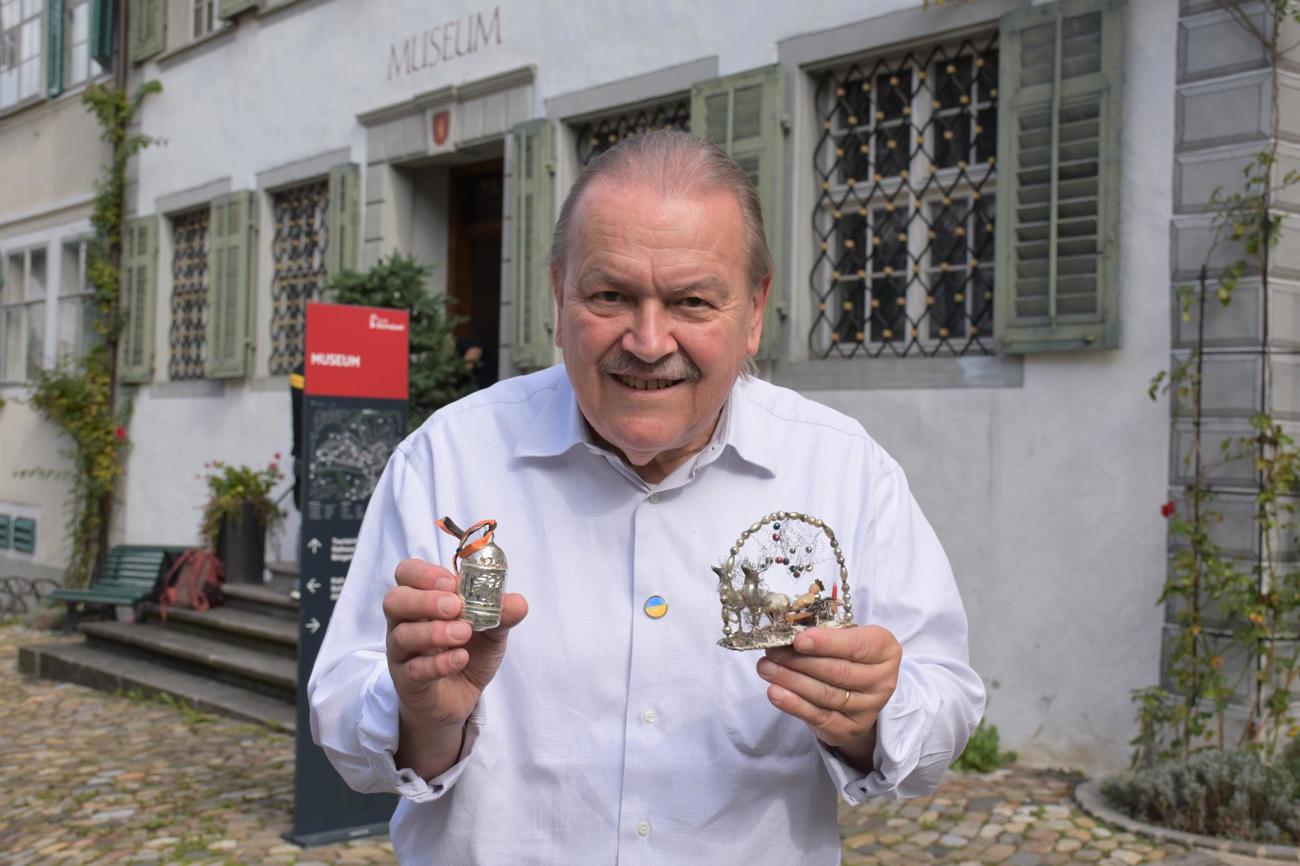 Spannungsfeld zwischen Kriegsgeschehen und Weihnachtsfreude zur Zeit des Ersten Weltkriegs: Sammler Alfred
Dünnenberger mit einer Christbaumkugel in Form einer Bombe und der Weihnachtsdekoration «Christkind auf
Schlitten mit Hirschen».