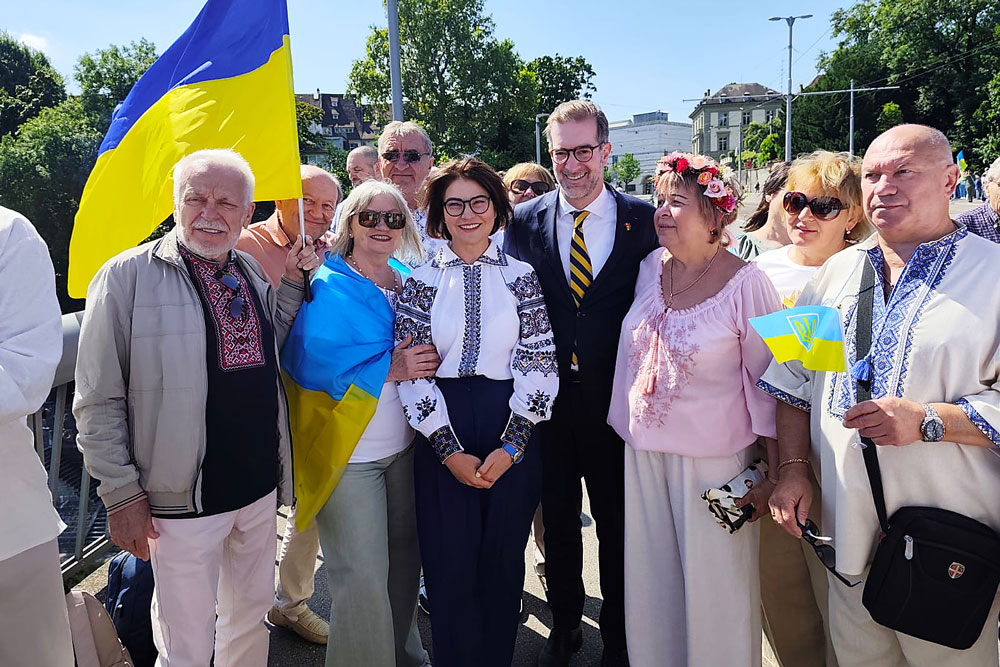 Nach dem Gottesdienst reisten viele Besucherinnen und Besucher nach Basel. Dort bildeten sie eine Menschenkette als Teil einer weltweiten Initiative. In der Mitte: Botschafterin Iryna Venediktova neben Conradin Cramer, dem Regierungspräsidenten von Basel-Stadt. | Foto: zvg