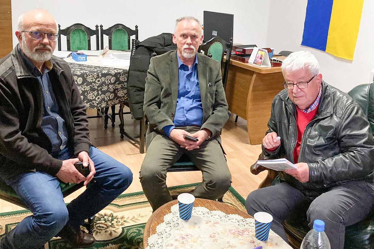 Pfarrer Andreas Hess (rechts) mit seinem Dolmetscher (links) im Büro des Bürgermeisters von Tiszápéterfalva/
Karpato, Ukraine (Mitte). (Bild: zVg)